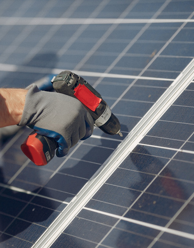 Engineer in a white helmet. Man near solar panel.